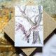 A simple white card featuring a sketch of a barn owl in flight, dramatic against an old tree. It is wintry and atmospheric. 